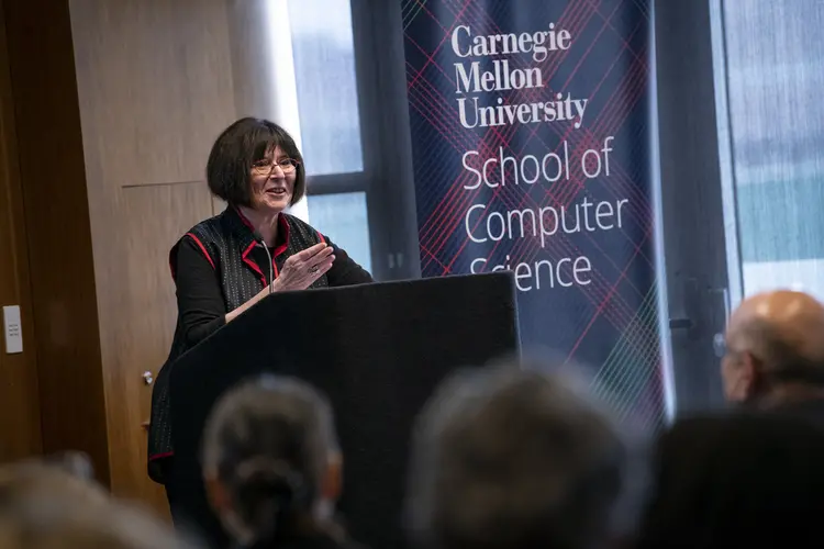 Lenore Blum standing at a podium.